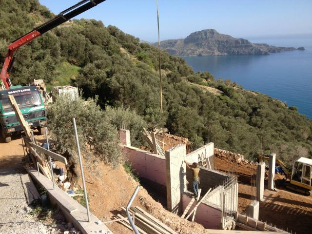 אתר בנייה ביוון עם נוף לים כחלק מפרויקט מגורים בתהליך הקמה