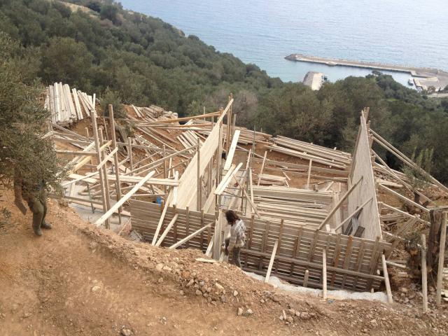 שלב שלד באתר בנייה עם תבניות בטון ונוף לים