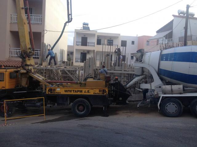 יציקת בטון באתר בנייה בכרתים עם משאבת בטון ומשאית ערבול