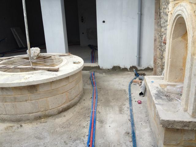 תשתיות מים וניקוז בחצר בית מסורתי במסגרת פרויקט בנייה בכרתים