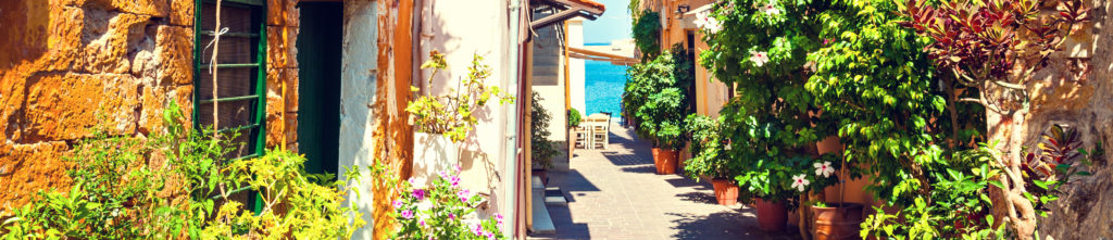 סמטה בכפר מסורתי בכרתים, יוון, עם בתים צבעוניים ואווירה מקומית