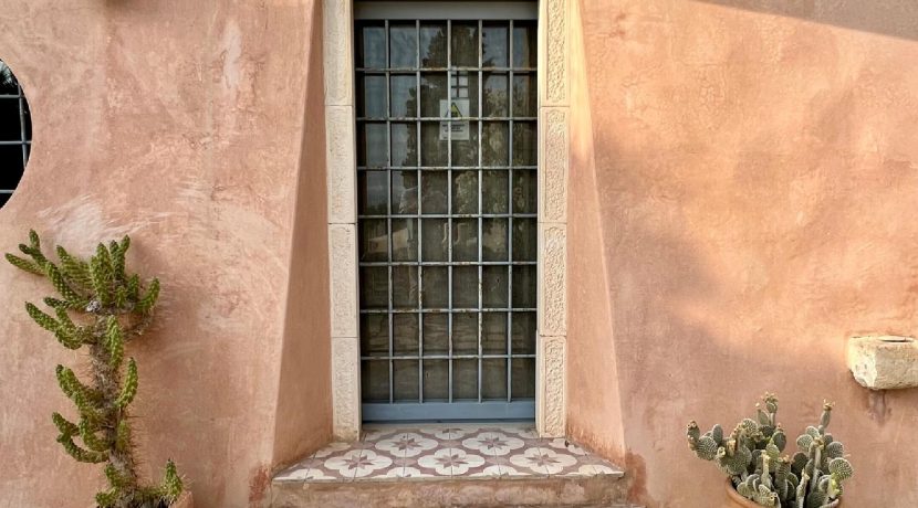 כניסה מעוצבת לבית פרטי עם קיר טיח טבעי בפרויקט מגורים מוגמר בכרתים