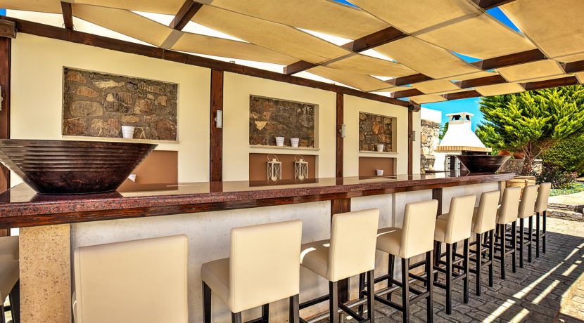 אזור ישיבה חיצוני מעוצב בפרויקט יוקרה בכרתים עם בר ונוף פתוח