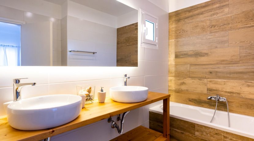 חדר רחצה מודרני עם חיפויי עץ וכלים סניטריים בעיצוב נקי