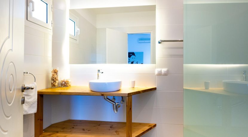 חדר רחצה מודרני בשילוב עץ בעיצוב נקי בפרויקט מגורים בכרתים