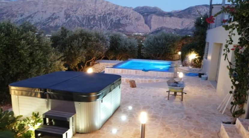 מתחם מגורים יוקרתי בכרתים בשעות הערב עם בריכה ונוף הרים